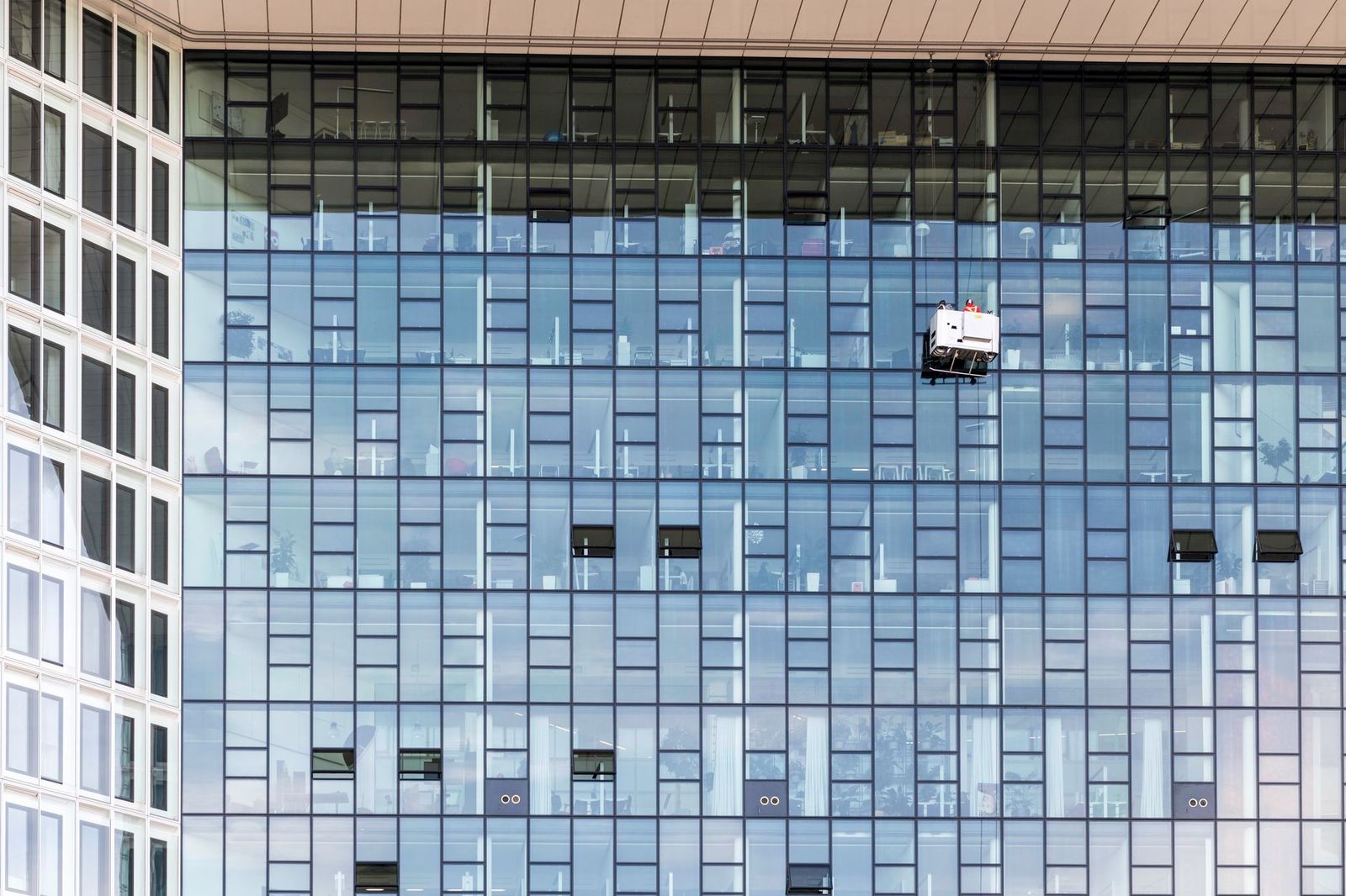 Maintenance gondola on the large glass façade of an office building